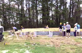 Members of Habitat for Humanity and Hawkes Learning start building on top of the future house's foundation.