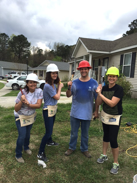 Venessa, Florie, Jeff, and Laura pose on the lawn with hammers in hand.