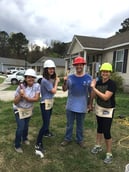 Venessa, Florie, Jeff, and Laura pose on the lawn with hammers in hand.