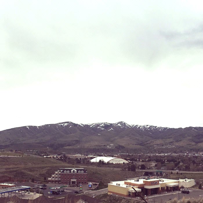 An overcast sky looms over the mountains behind the school buildings.