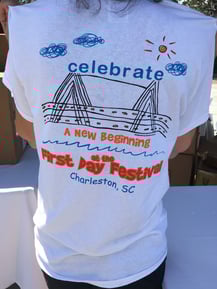 The back of a T-shirt that says 'Celebrate a new beginning at the First Day Festival, Charleston, SC.'
