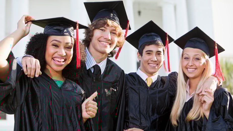 Friends celebrating college graduation in cap and gown.