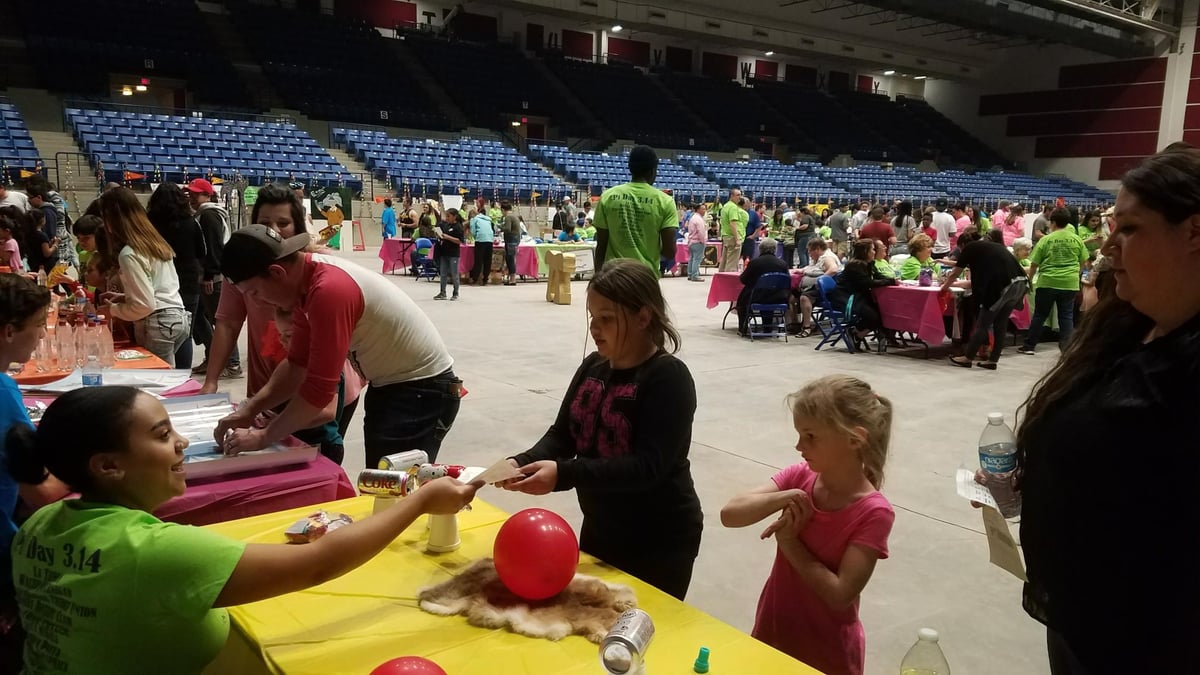 Children are given art supplies at a booth.