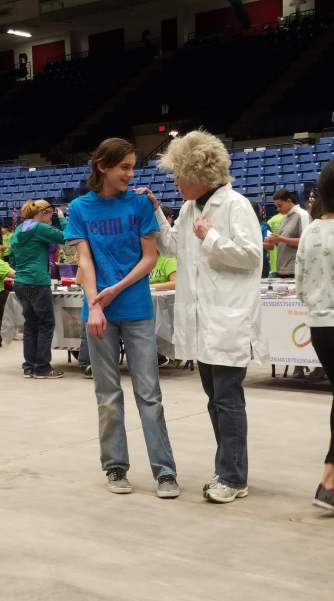 A student speaks with an instructor dressed as Albert Einstein.